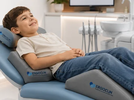 Niño sonriendo en el sillón dental apoyado en cojines Ergoclin